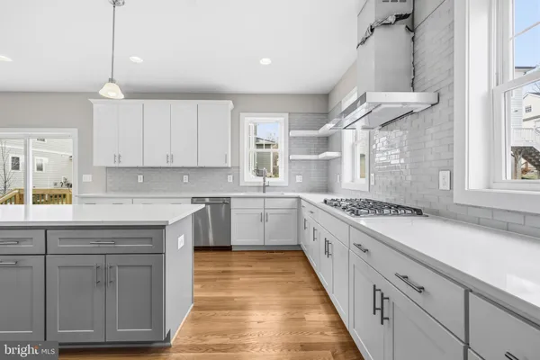 a large kitchen with white cabinets and white appliances