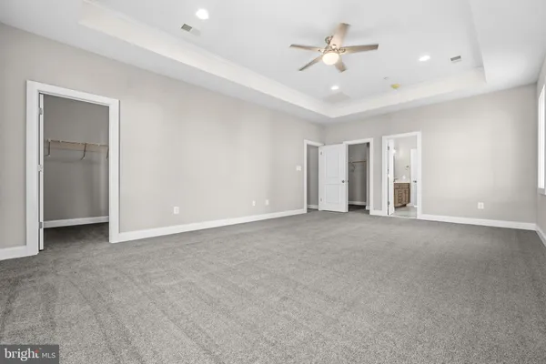 a view of a big room with chandelier fan and windows