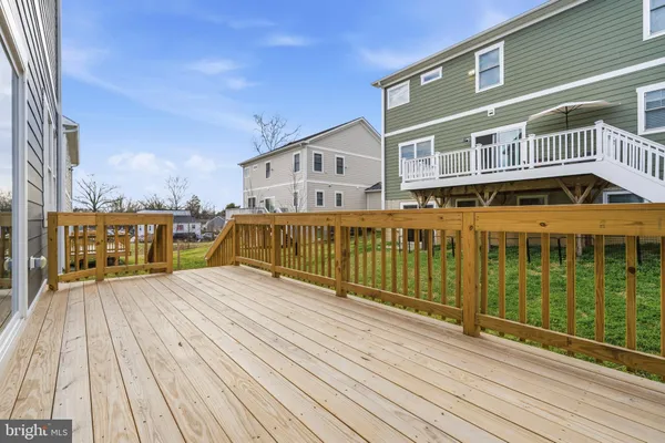 a view of balcony with wooden floor and fence and a floor to ceiling window