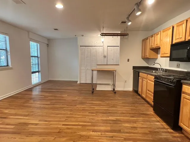 a view of a kitchen with a sink wooden cabinets and stainless steel appliances