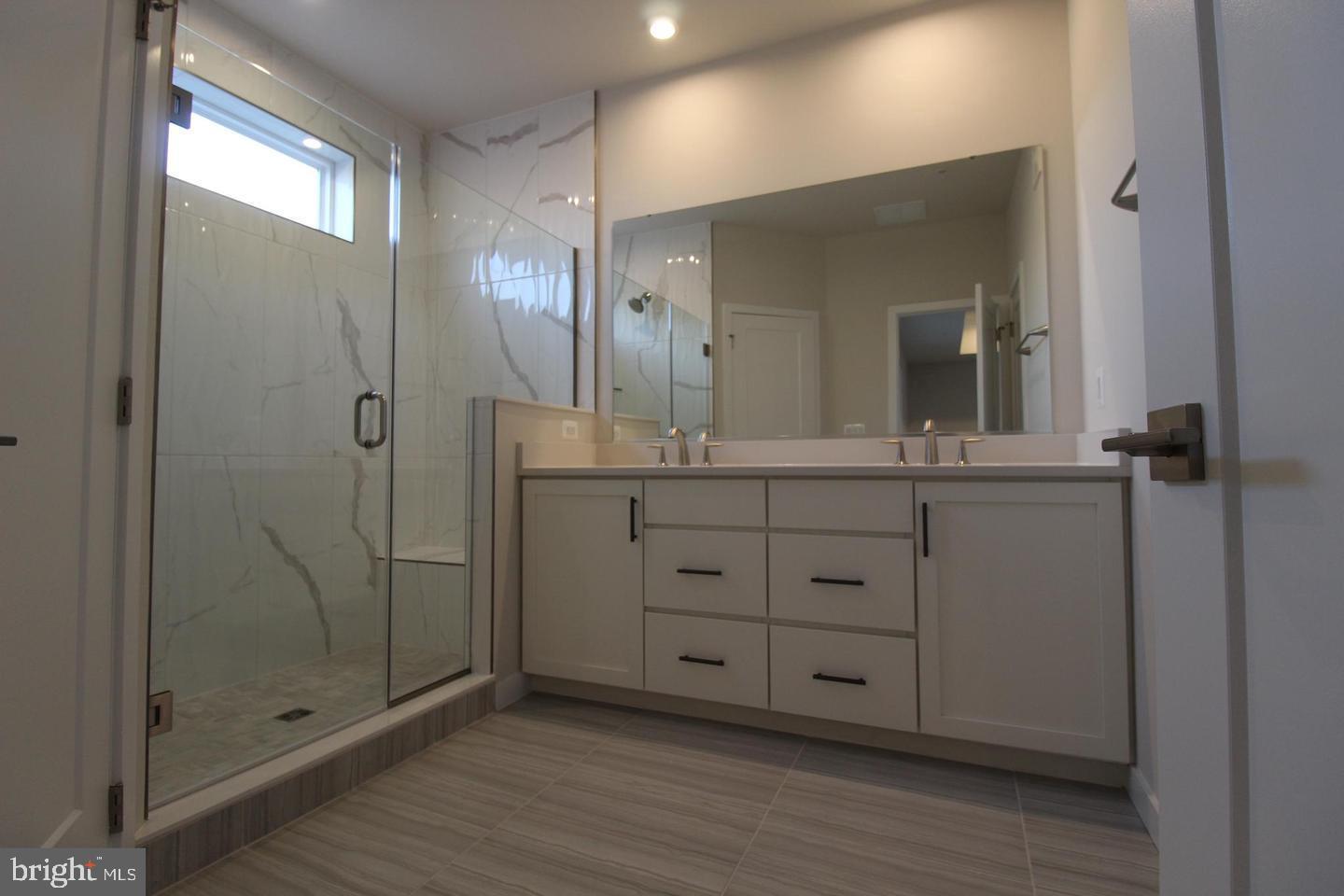 22383 Roanoke Rise Terrace Ashburn, VA 20148 - Photo 25 of 41 a bathroom with a granite countertop sink a mirror and shower