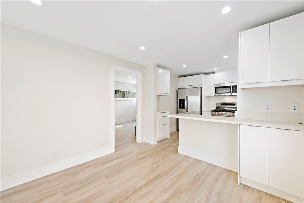 827 Cliff Drive Laguna Beach, CA 92651 - Photo 14 of 19 a kitchen with white cabinets and stainless steel appliances