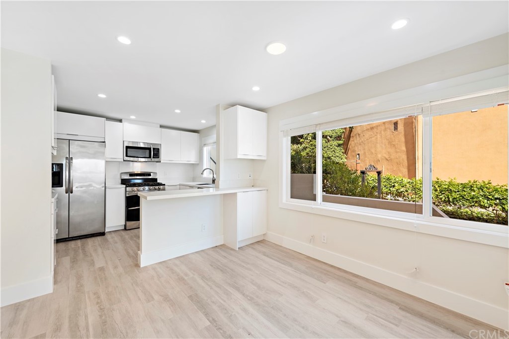 827 Cliff Drive Laguna Beach, CA 92651 - Photo 10 of 19 a kitchen with white cabinets and appliances