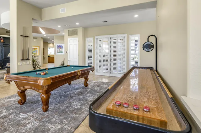 a room with pool table and windows