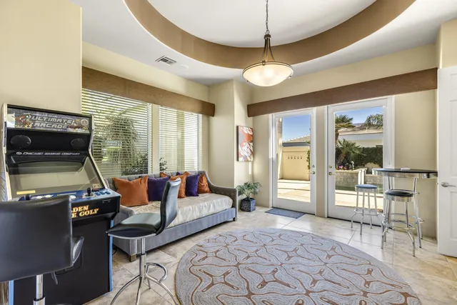 a living room with furniture a flat screen tv and a floor to ceiling window