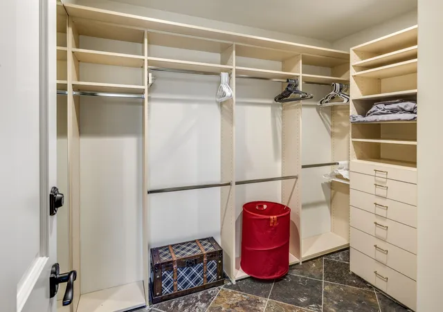 a view of walk in closet with empty racks