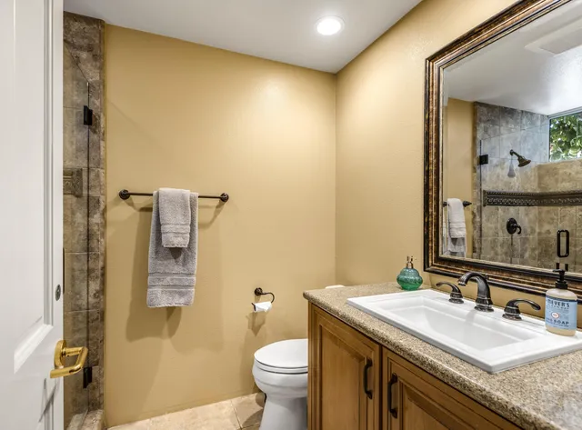 a bathroom with a granite countertop sink toilet and shower