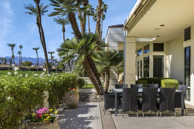 a front view of a house with a tree