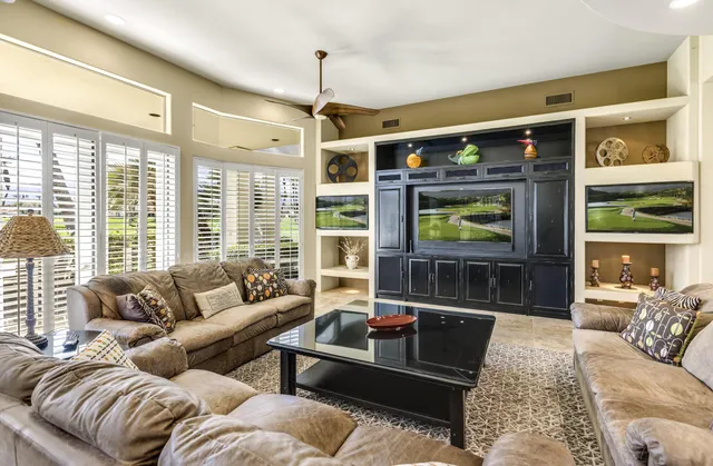 a living room with furniture and a ceiling fan