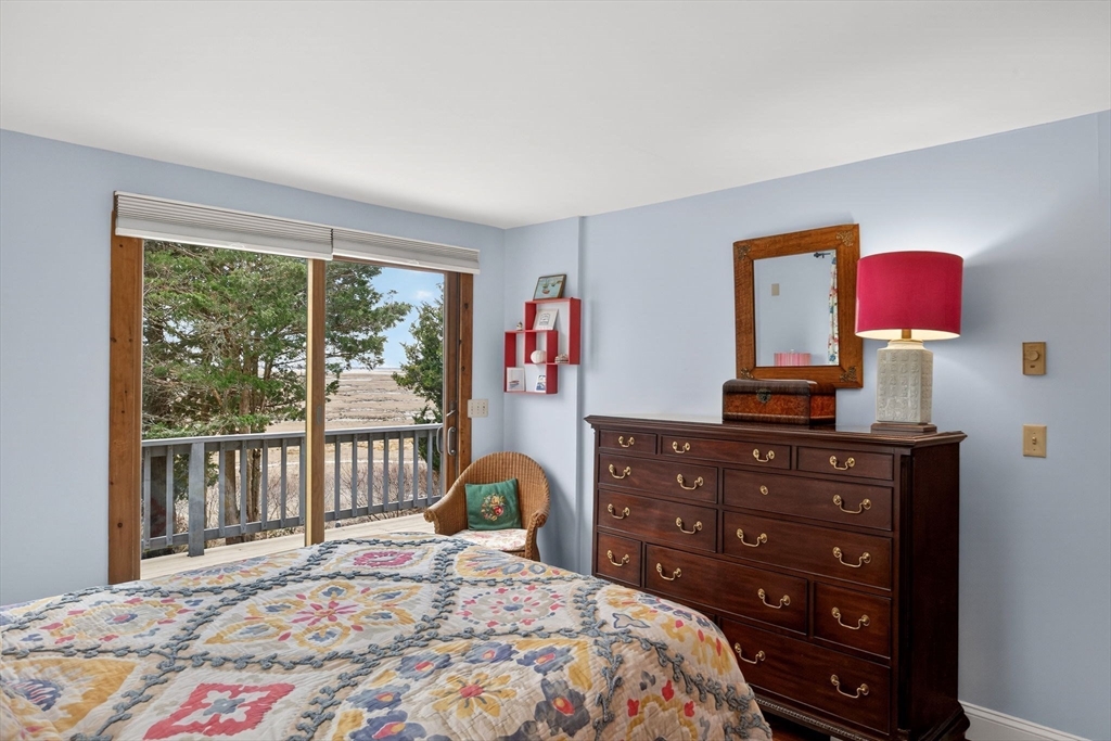 655 Herring Brook Road Eastham, MA 02642 - Photo 13 of 40 a bedroom with a bed a dresser and a window