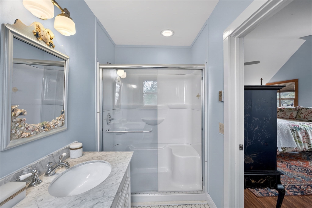 655 Herring Brook Road Eastham, MA 02642 - Photo 22 of 40 a bathroom with a granite countertop sink a mirror and shower