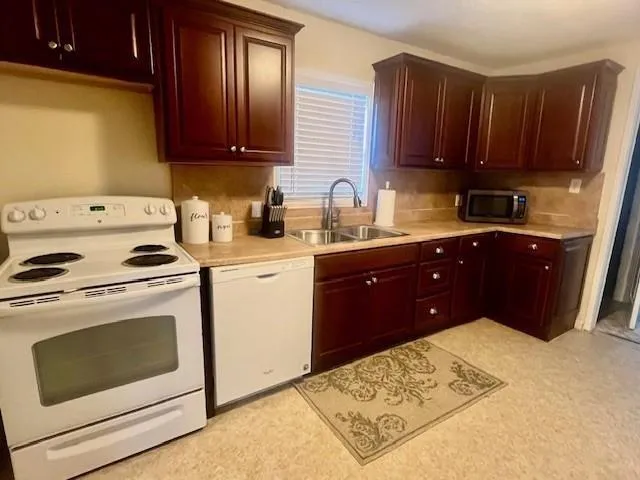 a kitchen with a cabinets and white appliances