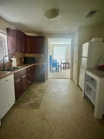 a kitchen with granite countertop a sink stove and refrigerator