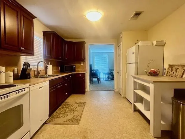 a large kitchen with cabinets a sink and dishwasher