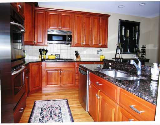 323 Village Road, Unit 32 Tiverton, RI 02878 - Photo 3 of 8 Kitchen. Custom features in this open kitchen with informal dining area. Granite counters with wider than normal breakfast bar and double ovens. Dining area with sliders open onto mahogany deck overlooking the bay.