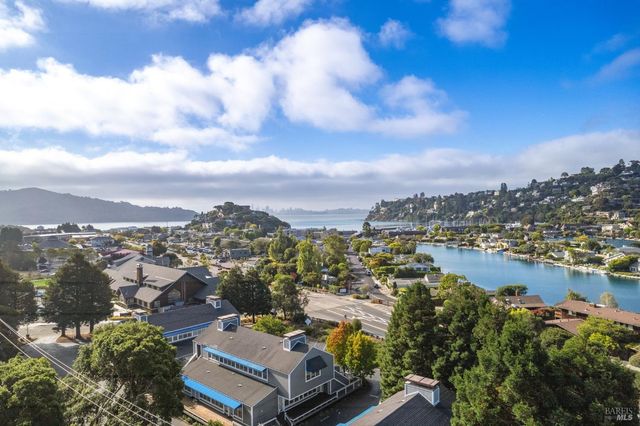 a kitchen with white cabinets and wooden floor