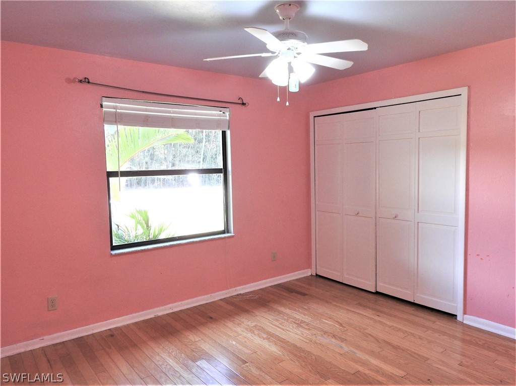 5936 Tarpon Road Bokeelia, FL 33922 - Photo 9 of 17 a view of an empty room with wooden floor and a window