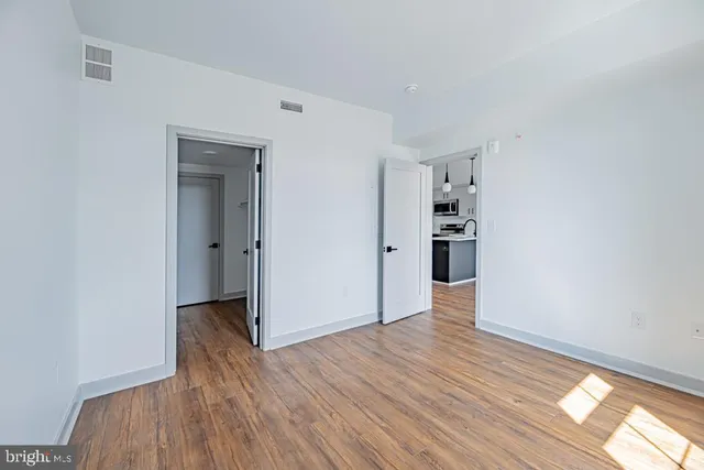 a view of empty room with wooden floor