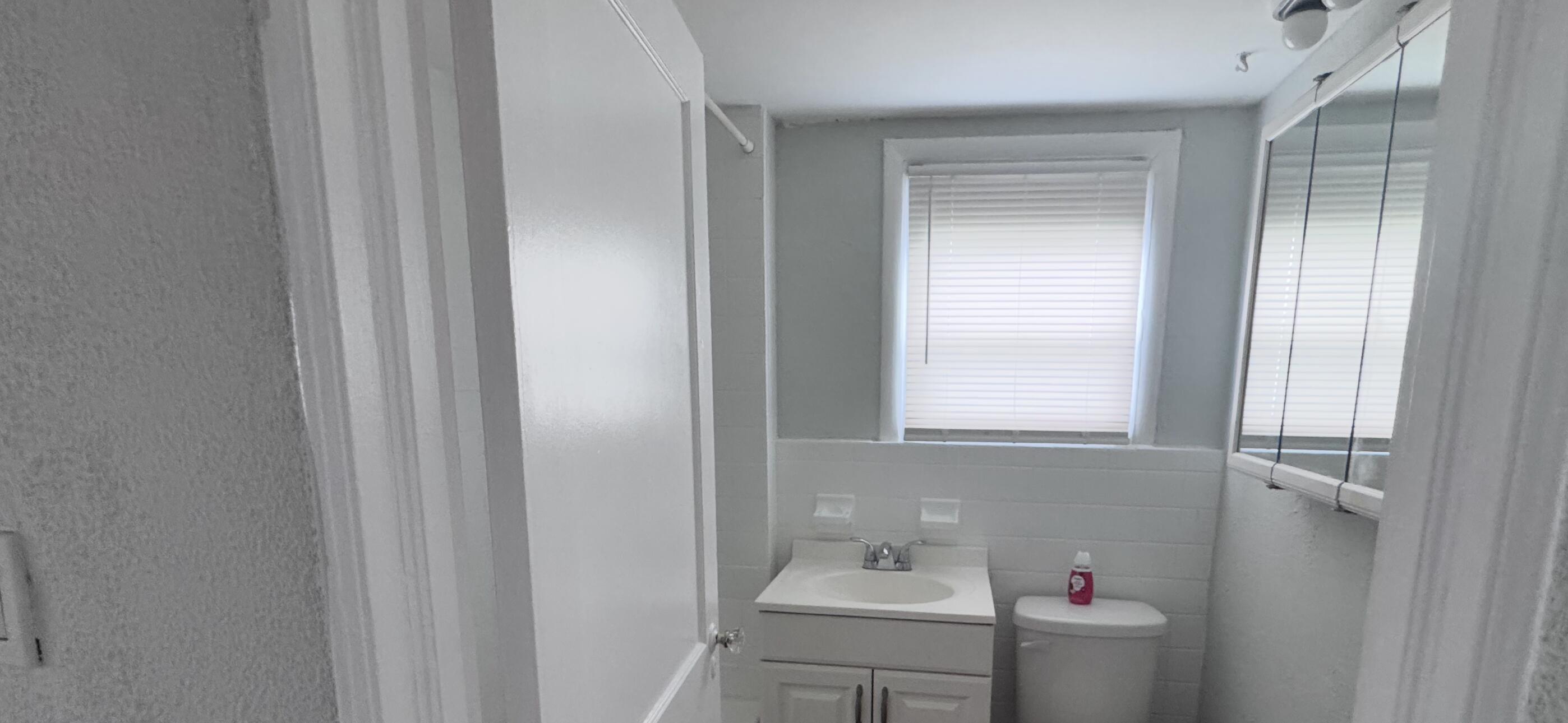 736 Omar Road, Unit 4 West Palm Beach, FL 33405 - Photo 4 of 17 a bathroom with a sink and a window
