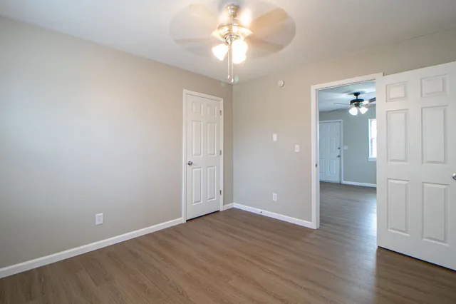 a view of an empty room with wooden floor
