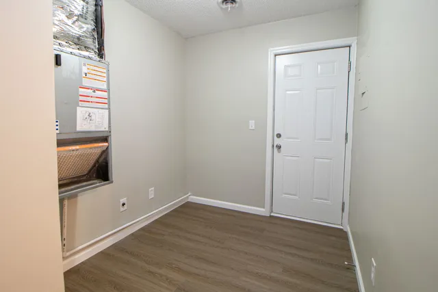 an empty room with wooden floor and mirror