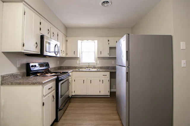 a kitchen with stainless steel appliances granite countertop a refrigerator and a stove