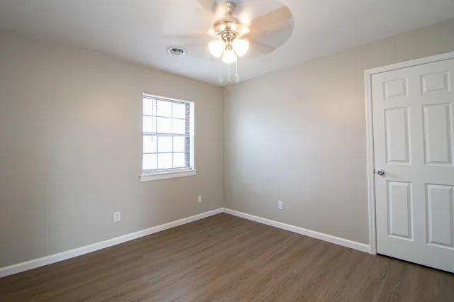 wooden floor in an empty room with a window