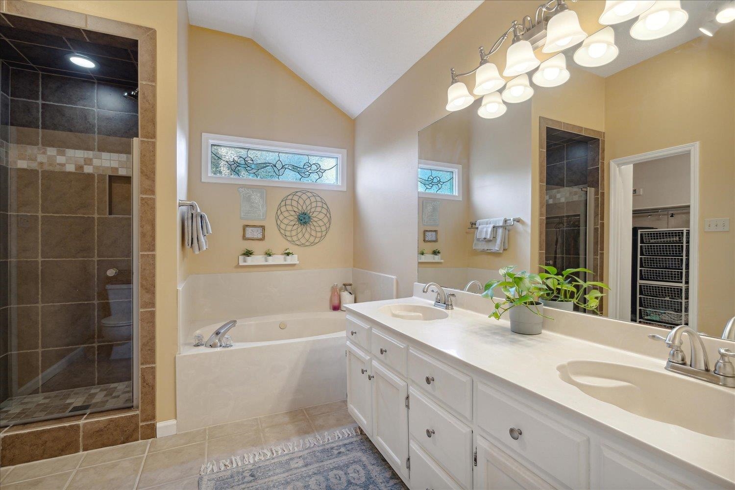 6893 Andrews Road Bartlett, TN 38135 - Photo 18 of 30 Bathroom featuring vanity, plus walk in shower, lofted ceiling, and tile patterned flooring