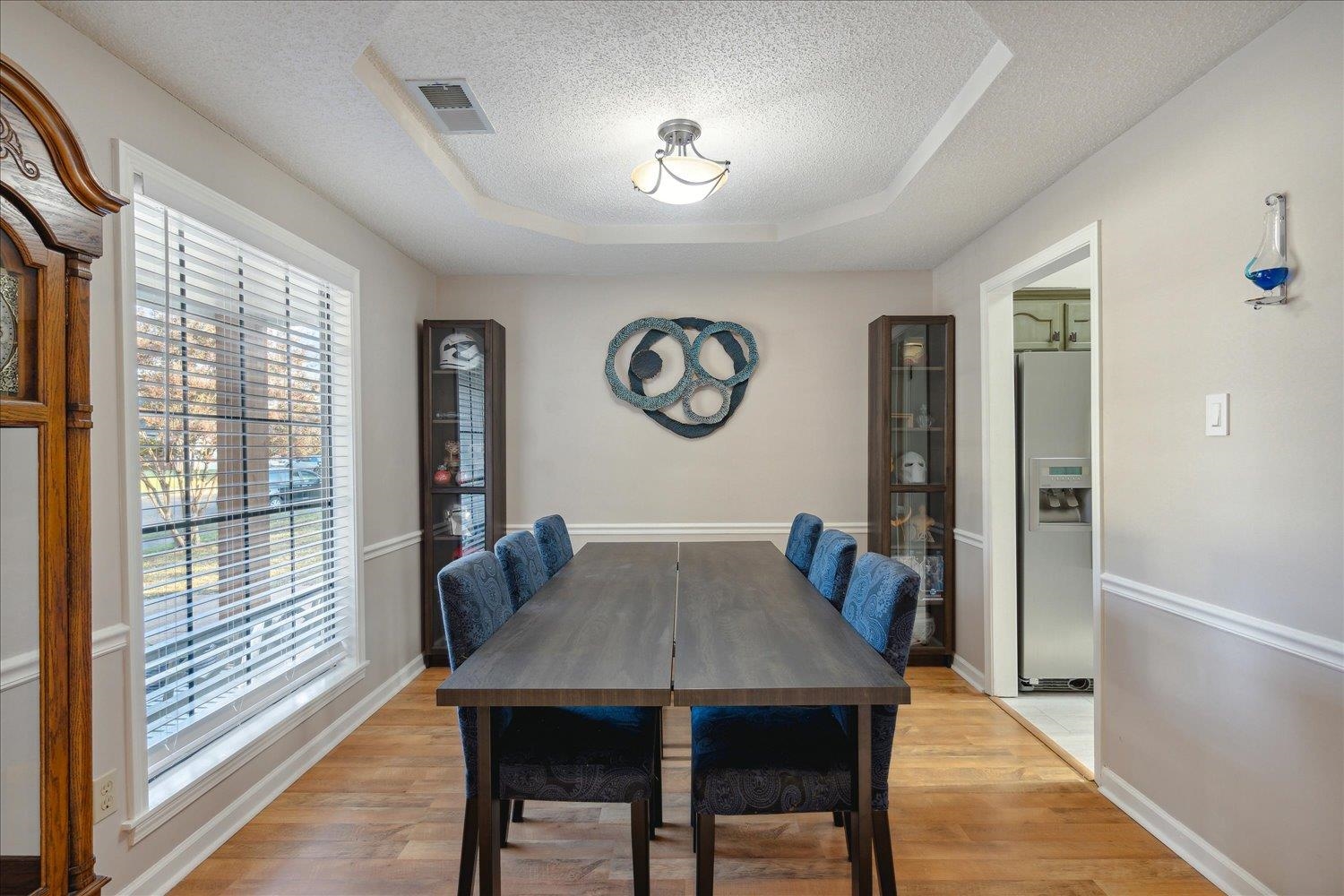 6893 Andrews Road Bartlett, TN 38135 - Photo 8 of 30 Dining area featuring a textured ceiling, light wood-type flooring, and a raised ceiling