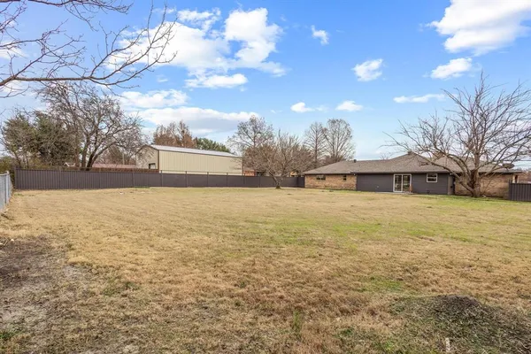 a view of house with yard and trees in the background