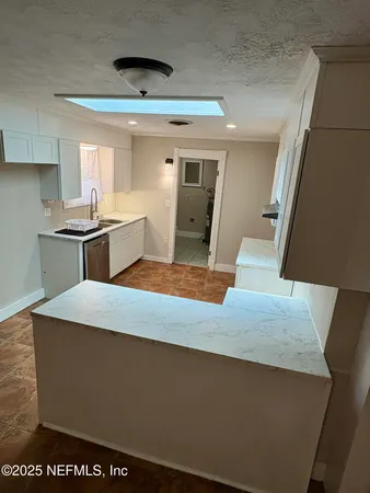 a kitchen with kitchen island granite countertop a sink and stove