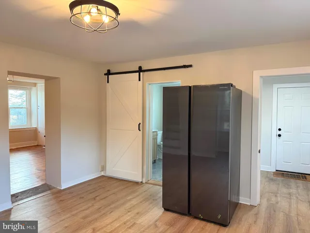 an empty room with wooden floor cabinet and windows