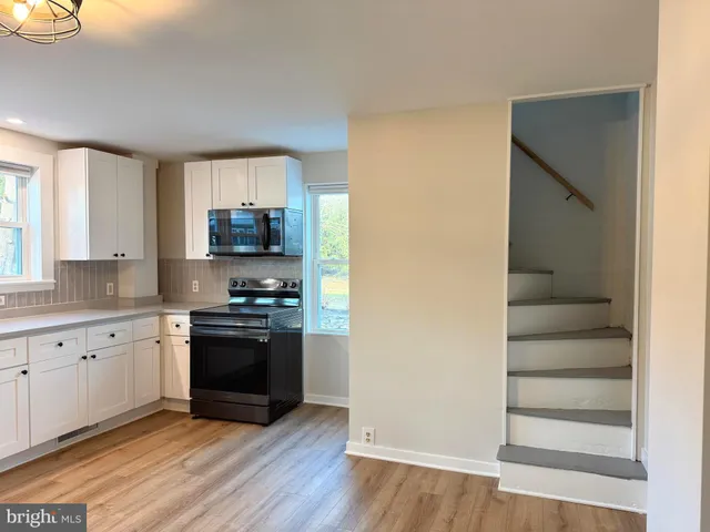 a kitchen with granite countertop white cabinets and stainless steel appliances