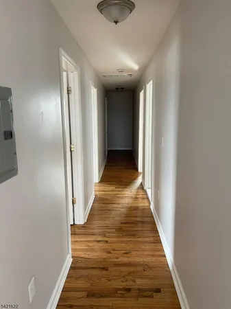 a view of a hallway with wooden floor