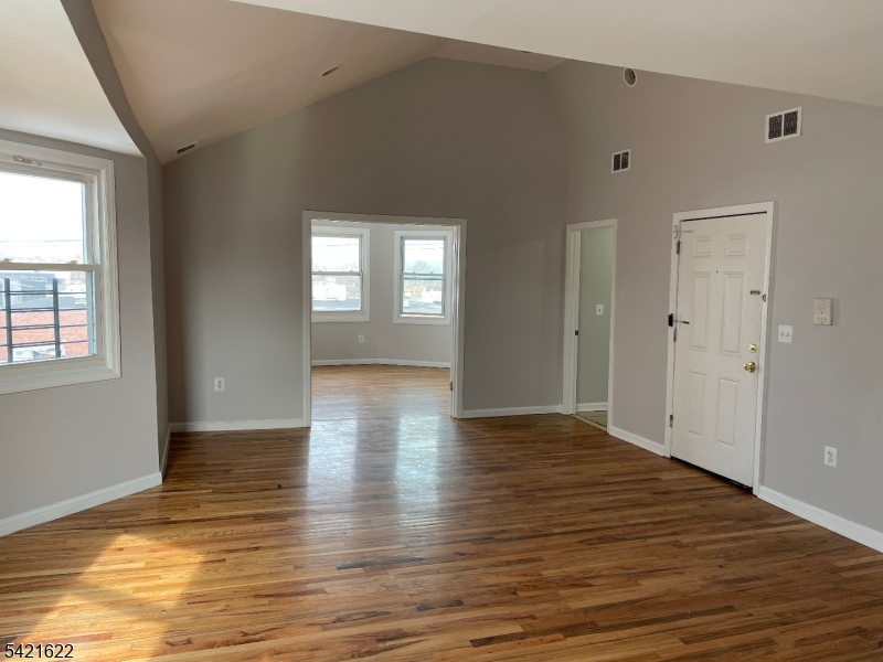 784 South 19th Street, Unit 2 Newark, NJ 07103 - Photo 2 of 11 an empty room with wooden floor and windows