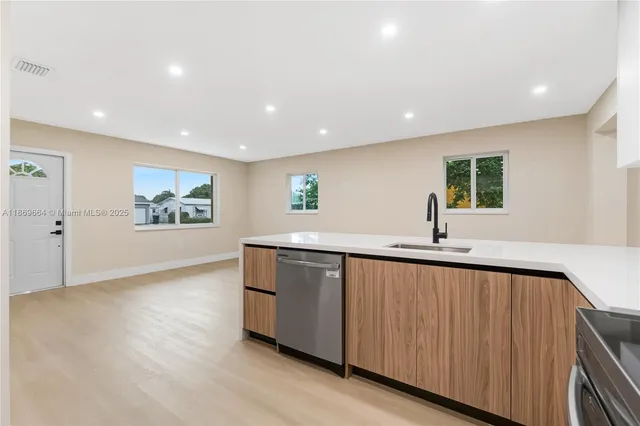 a view of kitchen with stainless steel appliances granite countertop a sink and a large window