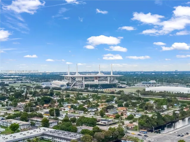 an aerial view of a city with lots of residential buildings ocean and mountain view in back