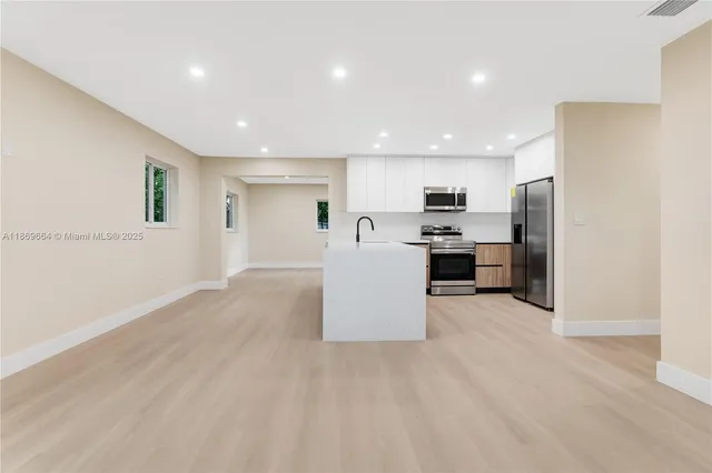 a view of kitchen with stainless steel appliances cabinets