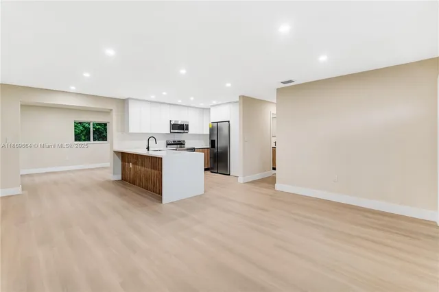 a large hall with stainless steel appliances granite countertop a large counter top and a stove top oven