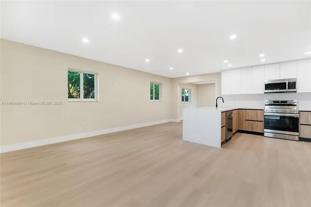 an empty room with furniture and a kitchen