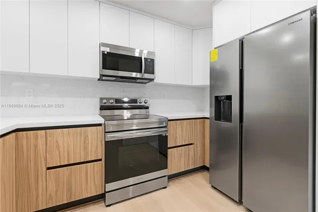 a kitchen with stainless steel appliances white cabinets and a granite counter top