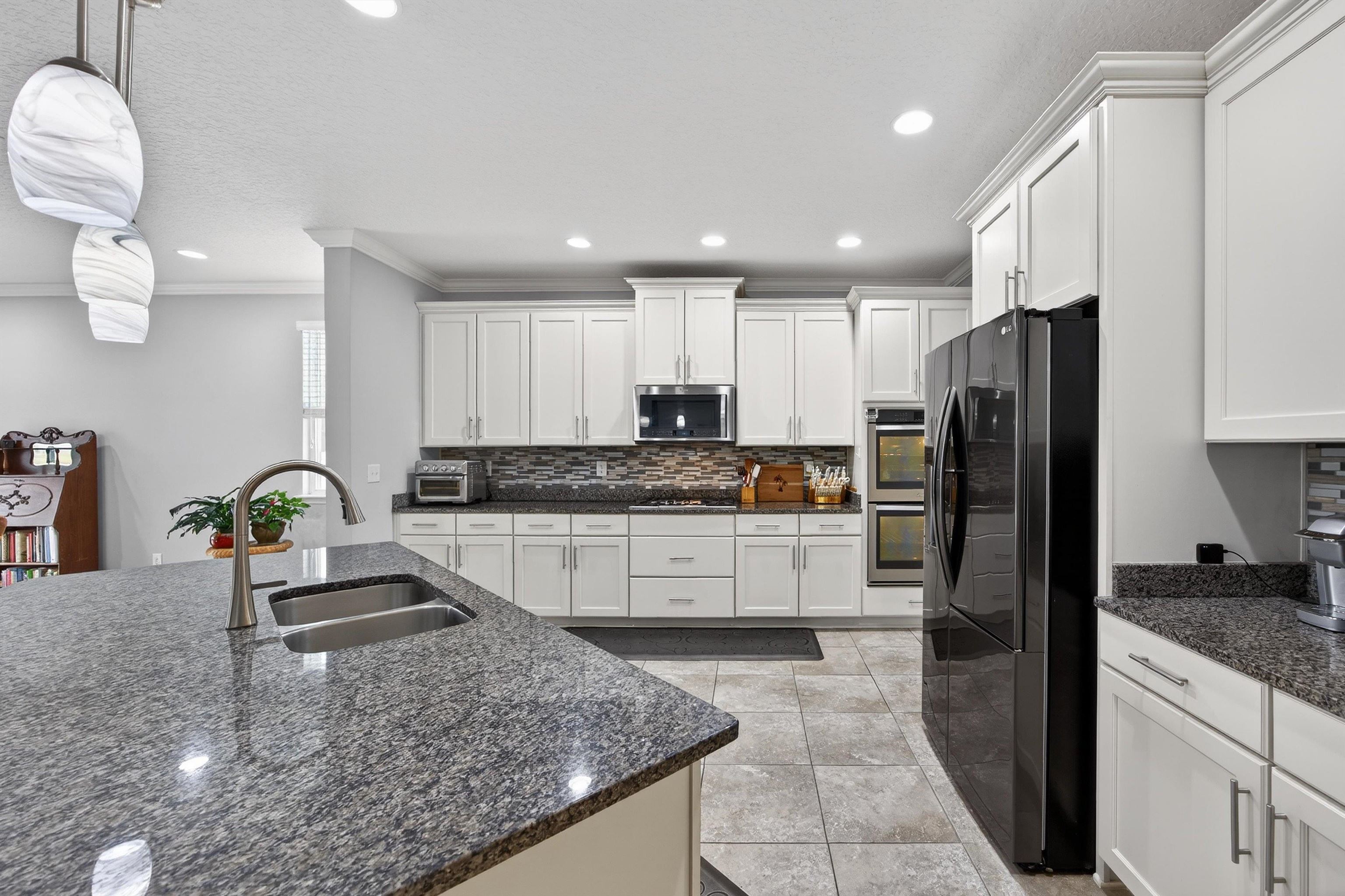 50 Sierras Loop St. Augustine, FL 32086 - Photo 9 of 37 a kitchen with granite countertop a refrigerator a sink a stove a microwave and island