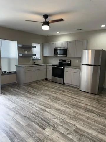 a kitchen with stainless steel appliances granite countertop a refrigerator sink and stove