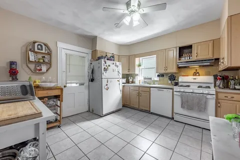 a view of a kitchen with fridge and workspace