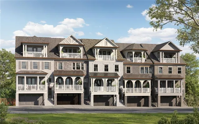 a front view of residential houses with yard and trees in the background