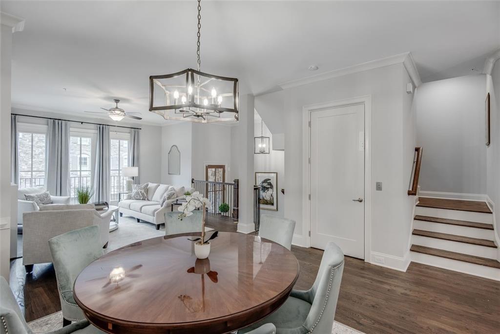 3450 Commander Cove Suwanee, GA 30024 - Photo 18 of 53 a dining room with wooden floor a chandelier a wooden table and chairs