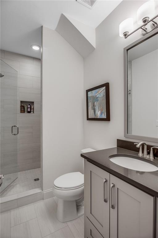 3450 Commander Cove Suwanee, GA 30024 - Photo 36 of 51 a bathroom with a granite countertop toilet sink and shower