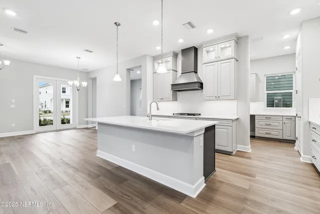 a kitchen with stainless steel appliances a stove and white cabinets
