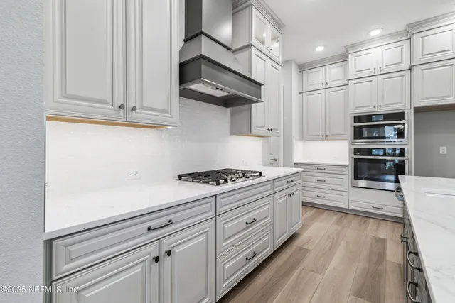 a kitchen with stainless steel appliances granite countertop a stove a sink and a microwave