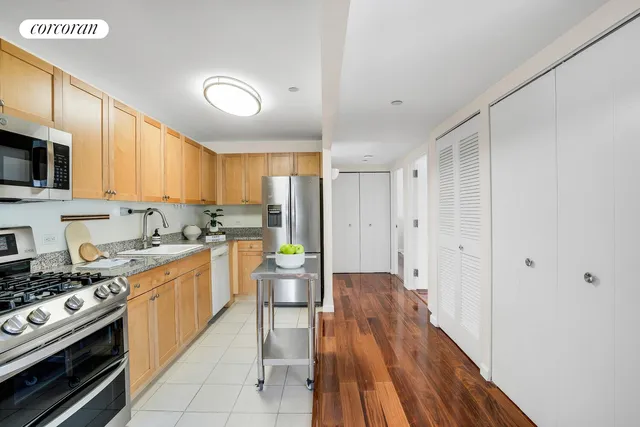 a kitchen with wooden floors and stainless steel appliances